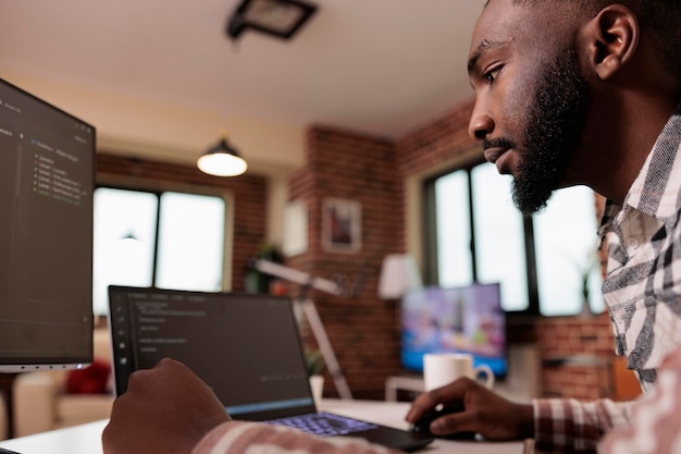 african american coder programming binary code interface, using css html script and encryption on computer. male freelancer coding security server with software developer application.
