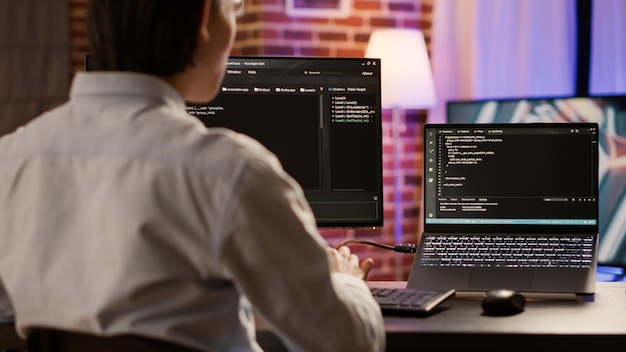 software developer coding firewall server on computer and laptop, using encryption system to script security network. programming binary code on data hacking application, text software.