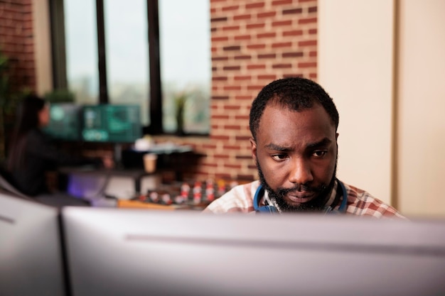 software developer typing javascript code on computer to develop online cloud computing information. african american tech enginner writing html script and data algorithm, working in it office
