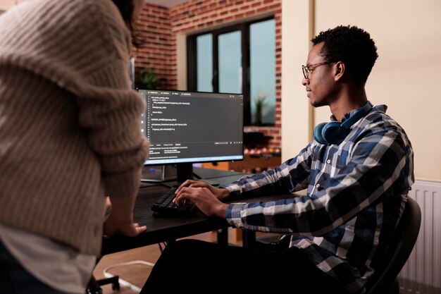 diverse cloud programers using computer to write code and develop algorithm program. tech enginners working on user interface with html script and terminal window in development company.