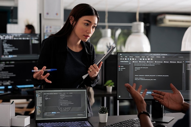 diverse team of app developers using computer to write html code and develop algorithm program in software company office. programmer working on user interface with html script and terminal window.