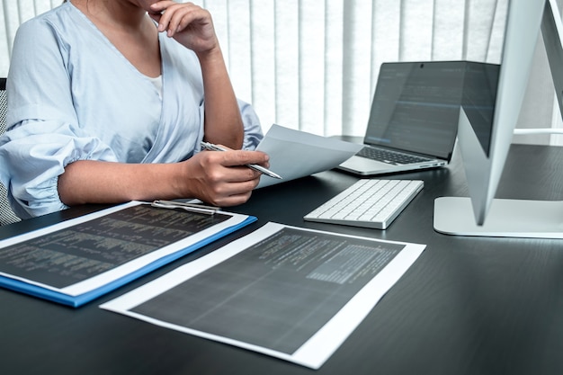 female programmer working in software javascript computer in it office, writing codes and data code website and coding database technologies to find solution to problem.