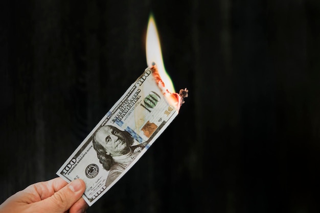 fire on banknotes on a black background concept of inflation a decrease in the purchase of foreign currency and devolution abandoning the dollar