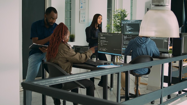 junior developer working on terminal window to code system script, using multiple monitors with source code database. programer writing algorithm with it html language, cloud computing.