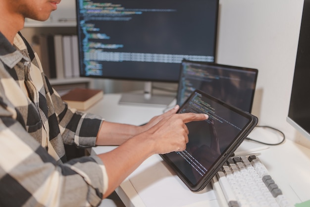 software developer coding on laptop and tablet in a modern workspace closeup of programming workflow software engineering debugging source code and multidevice application development
