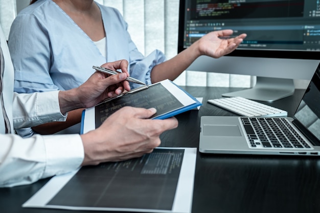 team of programmer working in software javascript computer in it office, writing codes and data code website and coding database technologies to find solution to problem.