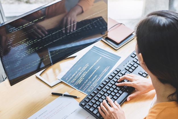 young professional programmer working at developing programming and website working in a software develop company office, writing codes and typing data code, programming with html, php and javascript
