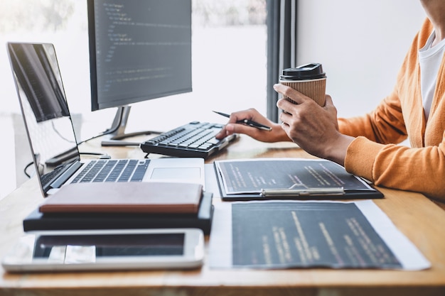 young professional programmer working at developing programming and website working in a software develop company office, writing codes and typing data code, programming with html, php and javascript