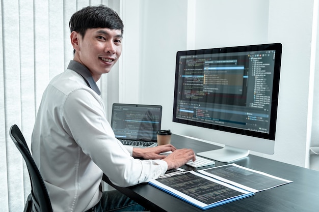 young programmer working in software javascript computer in it office, writing codes and data code website and coding database technologies to find solution to problem.